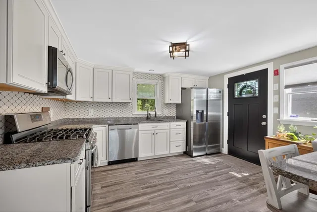 a kitchen with granite countertop a refrigerator stove top oven and sink