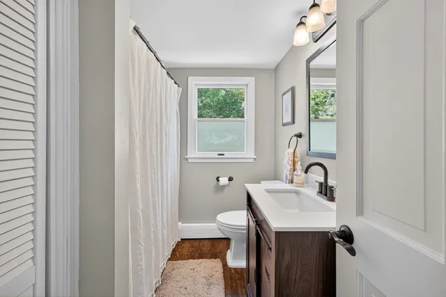 a bathroom with a sink a toilet and a mirror
