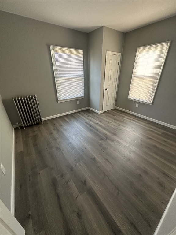 371 Dickinson Street, Unit 2 Springfield, MA 01108 - Photo 5 of 9 an empty room with wooden floor and windows