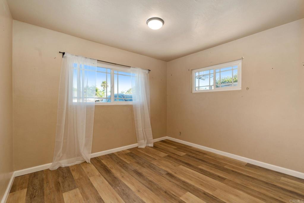 512 Tatum Street Vista, CA 92083 - Photo 11 of 26 an empty room with wooden floor and windows