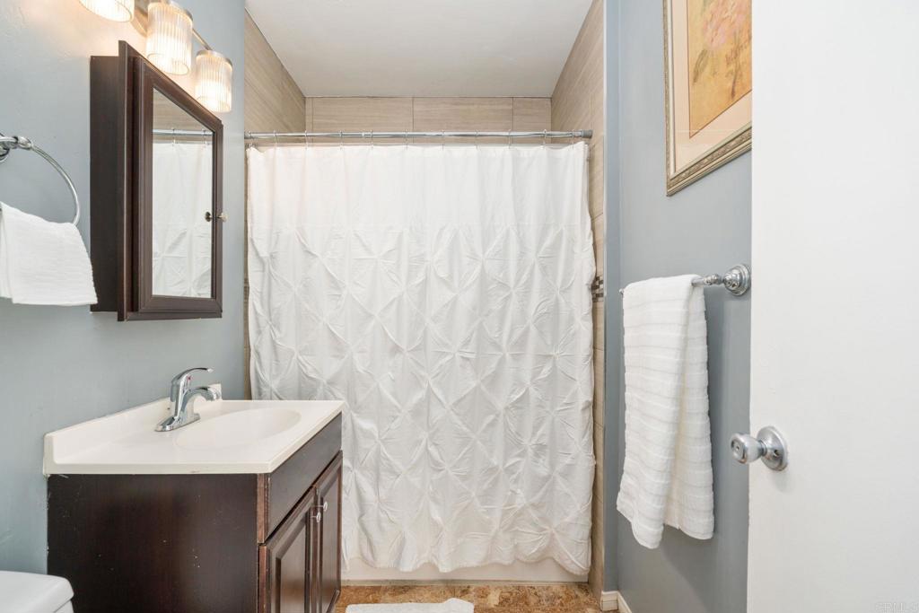 512 Tatum Street Vista, CA 92083 - Photo 13 of 26 a bathroom with a sink a mirror and a shower curtain