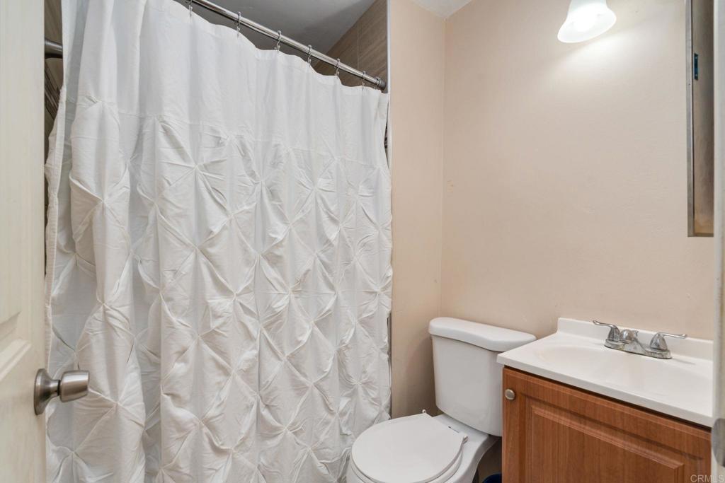 512 Tatum Street Vista, CA 92083 - Photo 16 of 26 a white toilet sitting next to a white sink and vanity