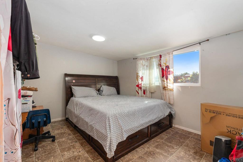 512 Tatum Street Vista, CA 92083 - Photo 17 of 26 a bedroom with a bed and a flat tv screen on the dresser