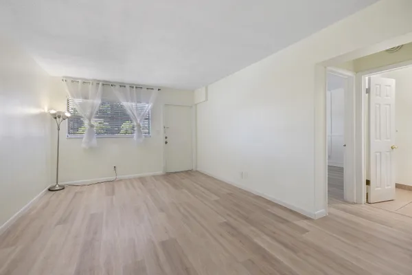a view of empty room with wooden floor