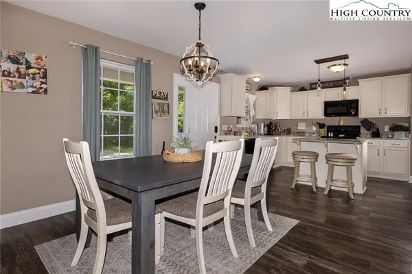 a dining room with furniture a chandelier and wooden floor