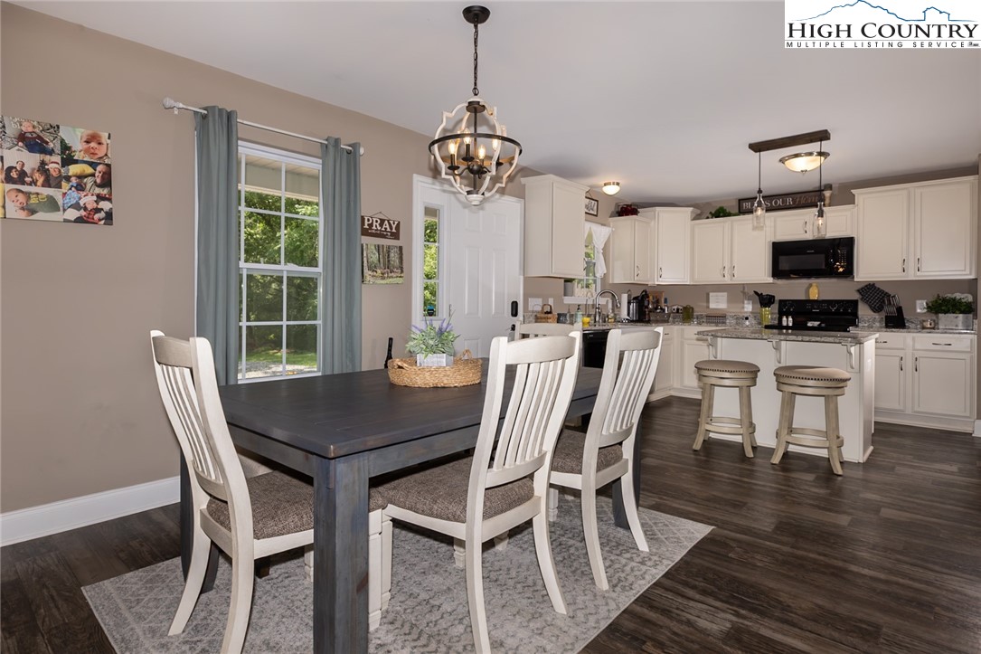 351 Colony Lane Purlear, NC 28665 - Photo 22 of 39 a dining room with furniture a chandelier and wooden floor