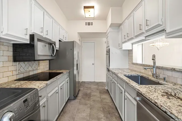 a kitchen with stainless steel appliances granite countertop a sink and dishwasher