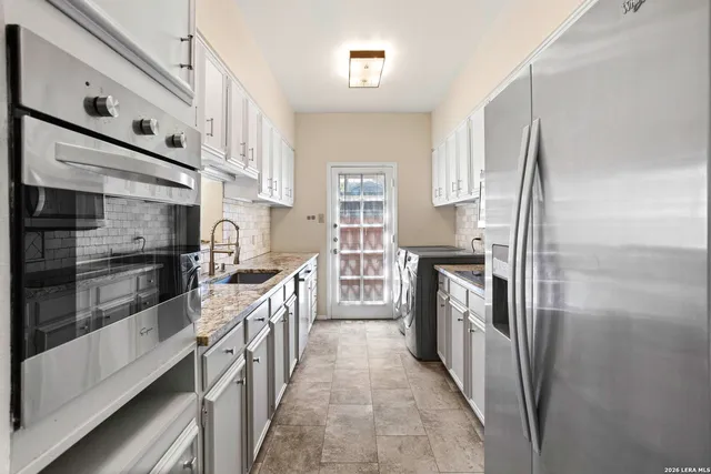 a kitchen with stainless steel appliances granite countertop a refrigerator and a stove