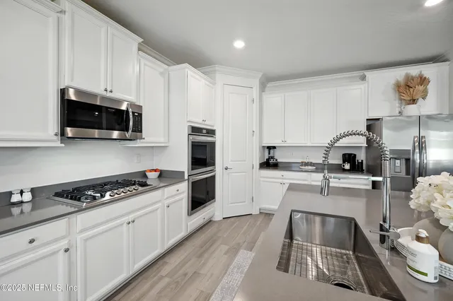a kitchen with stainless steel appliances white cabinets and a sink