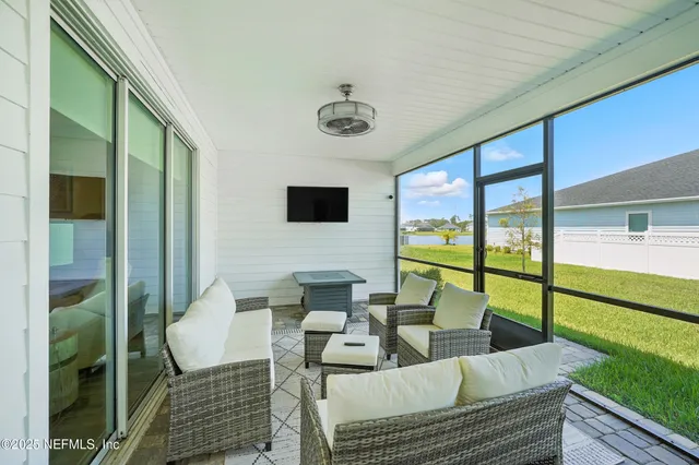 a living room with furniture and a floor to ceiling window