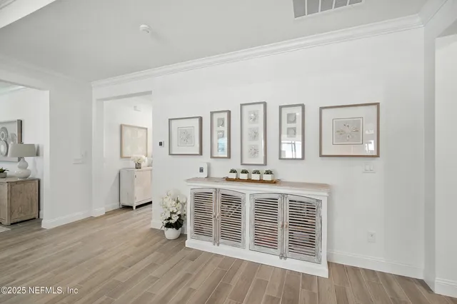 a hallway with white cabinets and window