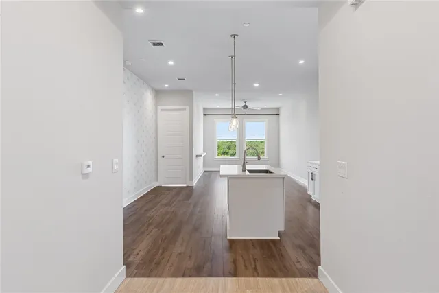 a view of a hallway with wooden floor and closet