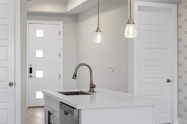 a kitchen with a sink a refrigerator and cabinets