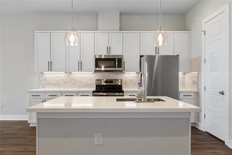 a kitchen with white cabinets and stainless steel appliances