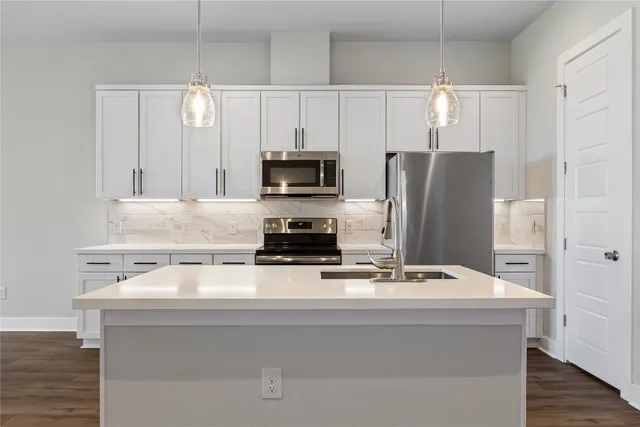 a kitchen with white cabinets and stainless steel appliances