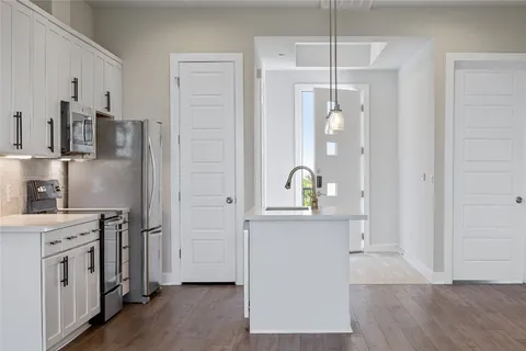 a kitchen with wooden floors and stainless steel appliances