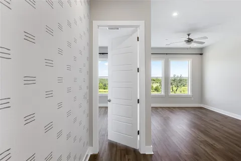 a large kitchen with a sink and wooden floor