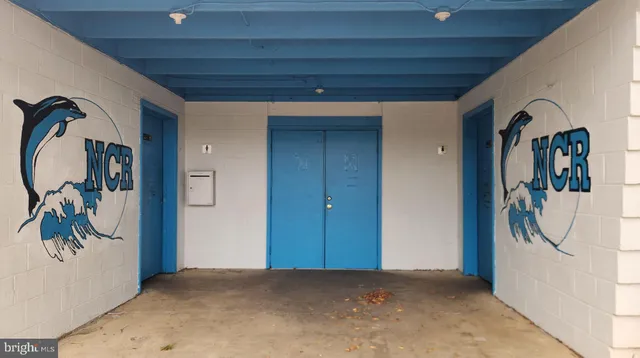 a view of a tennis ground with large trees