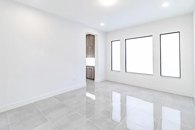 an empty room with staircase and a view of bathroom