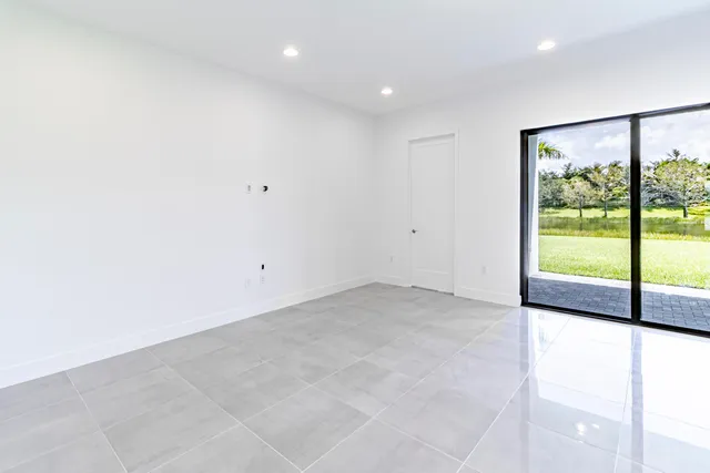an empty room with windows and cabinet