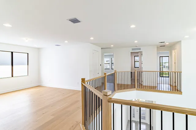 an empty room with wooden floor and sliding door