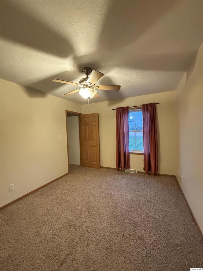 1848 North Co Road 1700 Carthage, IL 62321 - Photo 29 of 33 an empty room with windows and fan