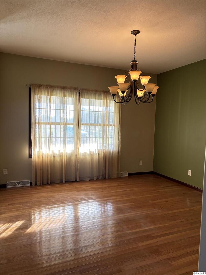 1848 North Co Road 1700 Carthage, IL 62321 - Photo 5 of 33 an empty room with wooden floor fan and windows