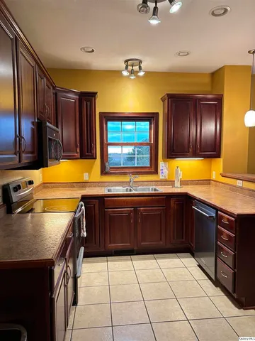 a kitchen with stainless steel appliances granite countertop a sink and cabinets
