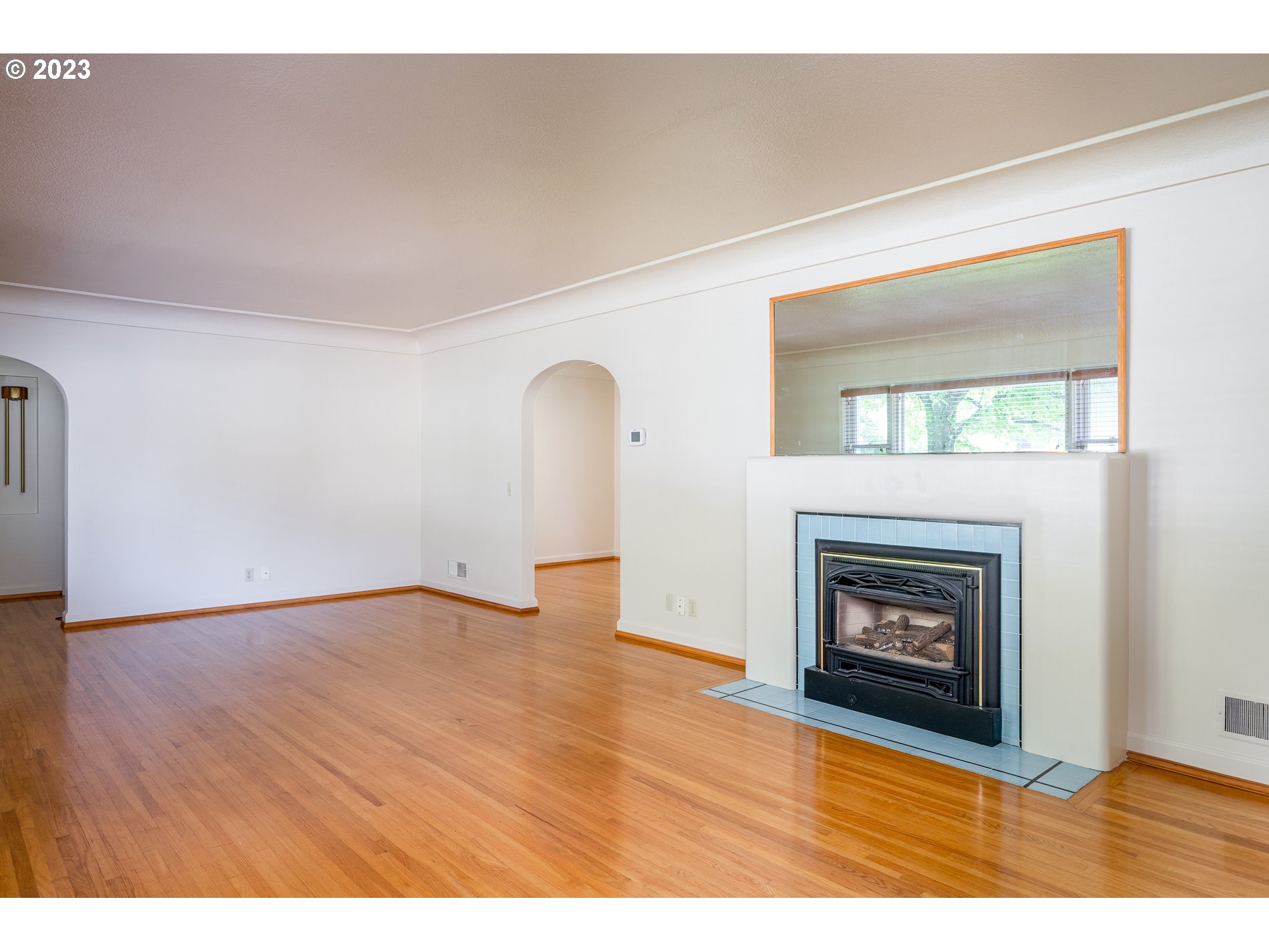 8201 Southwest 41st Avenue Portland, OR 97219 - Photo 5 of 23 a view of an empty room with wooden floor fireplace and a window