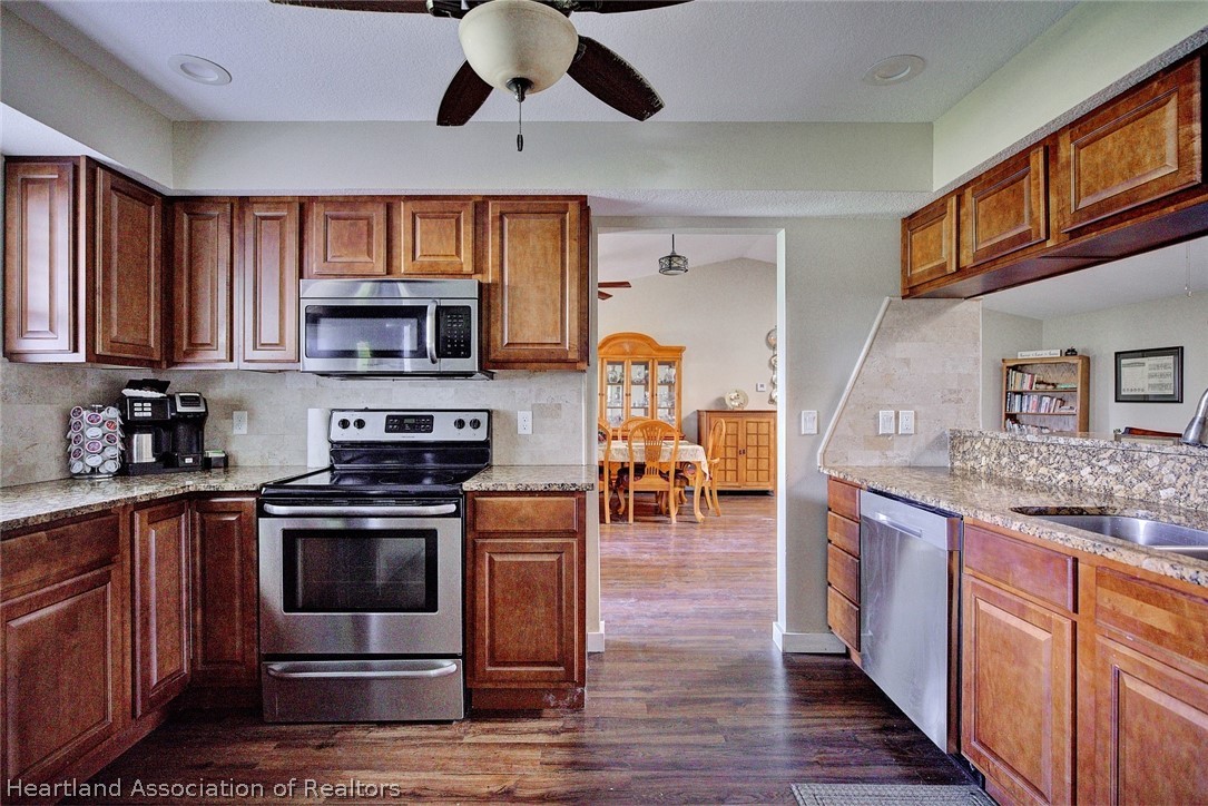 3601 Divot Road Sebring, FL 33872 - Photo 11 of 31 a kitchen with stainless steel appliances granite countertop wooden cabinets a stove top oven a sink and dishwasher