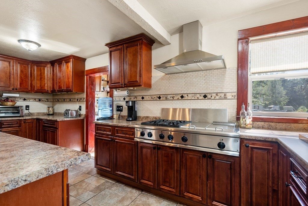 65 NW Road Westfield, MA 01085 - Photo 6 of 29 a kitchen with stainless steel appliances granite countertop wooden cabinets stove top oven and sink