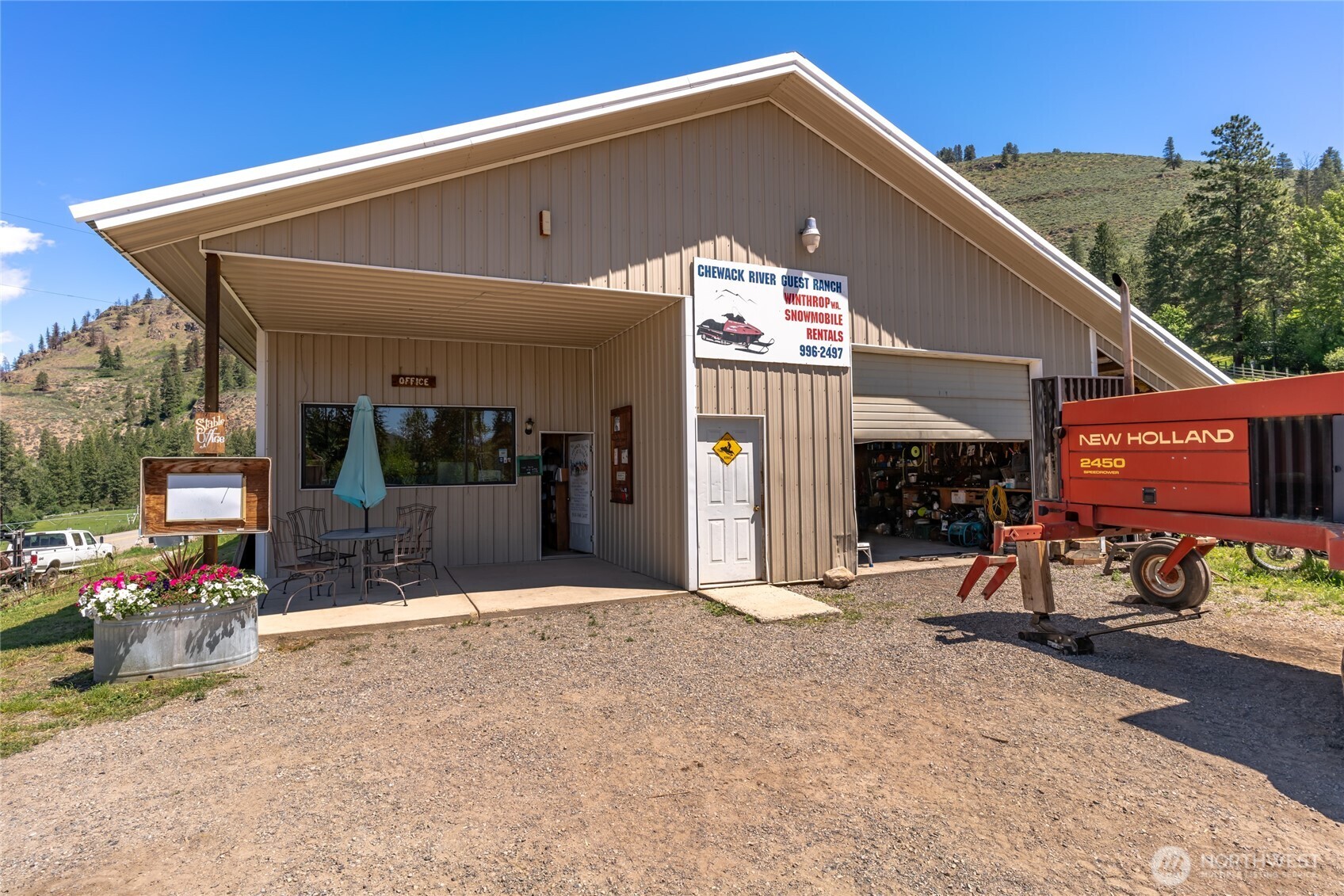 579 Eastside Chewuch Road Winthrop, WA 98862 - Photo 30 of 37 a front view of a house with patio outdoor seating and covered with trees in the background