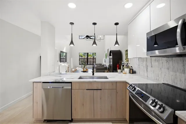 a kitchen with stainless steel appliances granite countertop a sink and a stove
