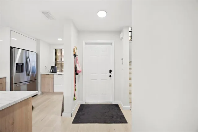 a hallway with cabinets and wooden floor