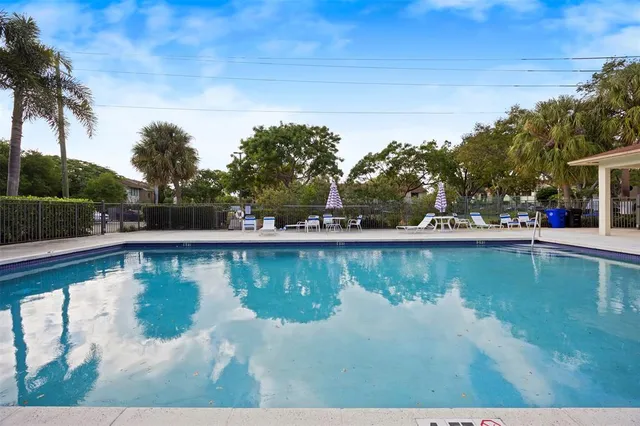 a view of house with swimming pool and sitting area
