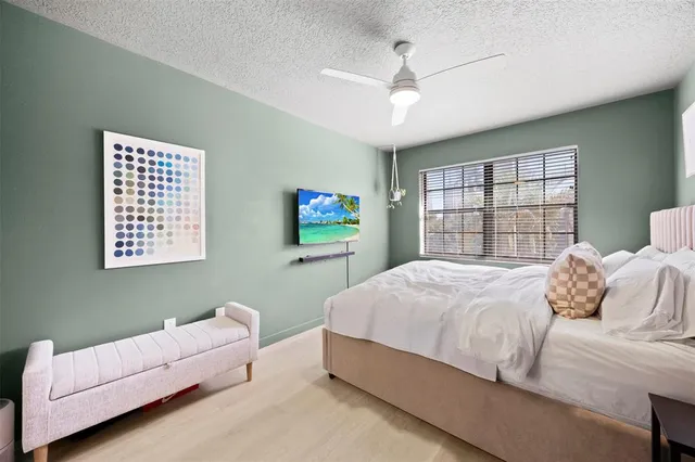 a bedroom with bed and a large window