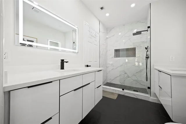 a bathroom with a sink a mirror and shower
