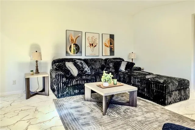 a living room with furniture a rug and a wall painting