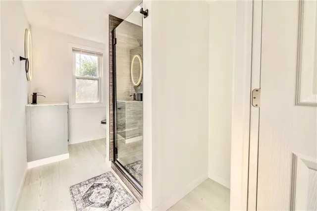 a view of a bathroom with mirror and door