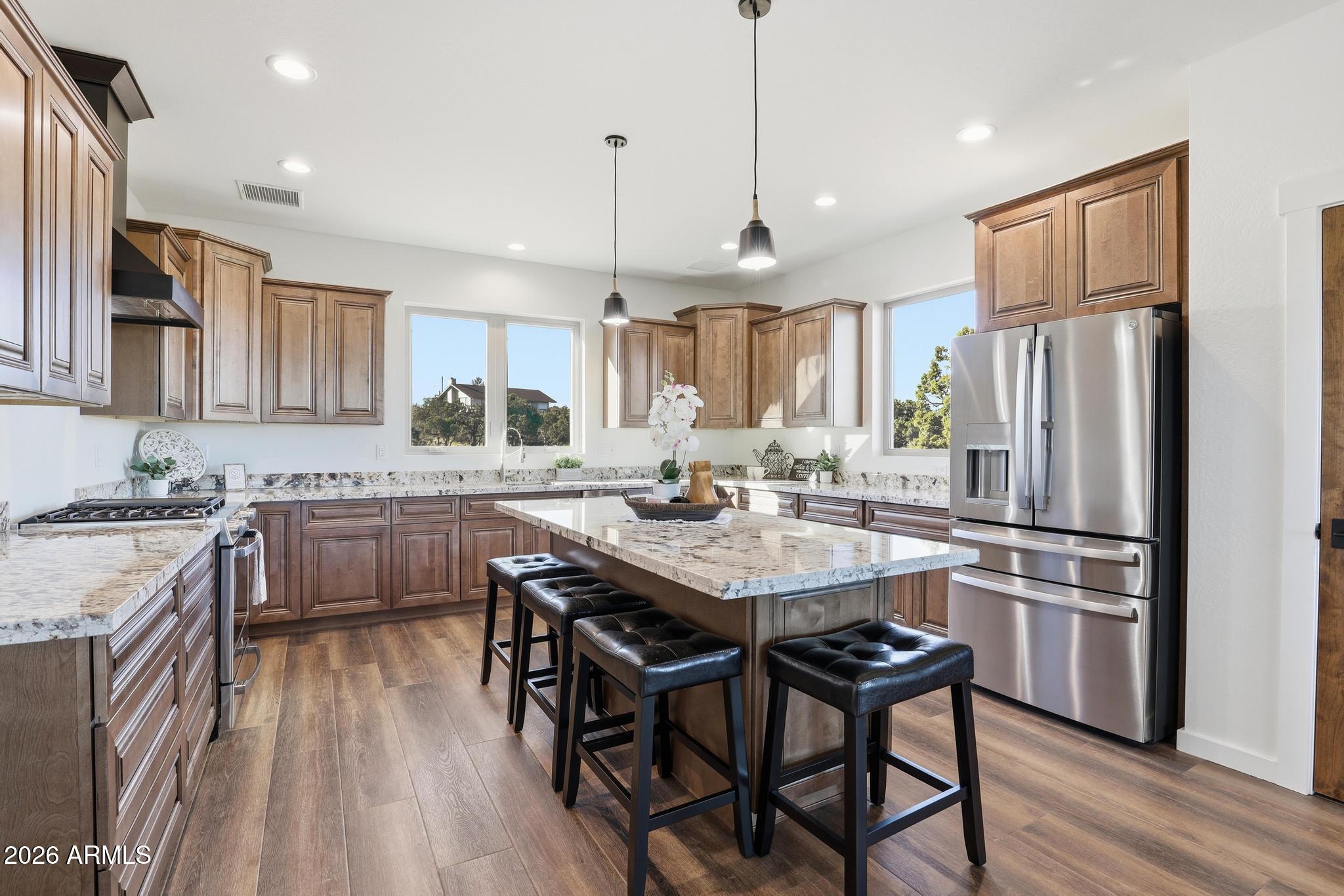 1105 South Kinzer Court Payson, AZ 85541 - Photo 17 of 44 a kitchen with refrigerator a sink and chairs