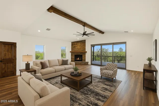 a living room with furniture fireplace and a large window
