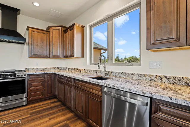 a kitchen with stainless steel appliances granite countertop a sink stove and cabinets