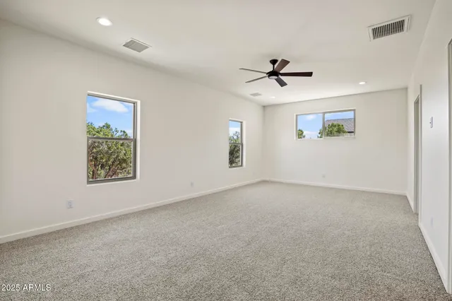 an empty room with windows and fan