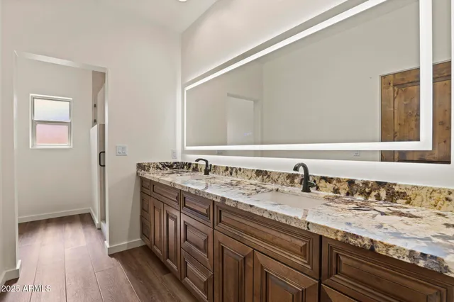 a bathroom with a granite countertop sink and a large mirror