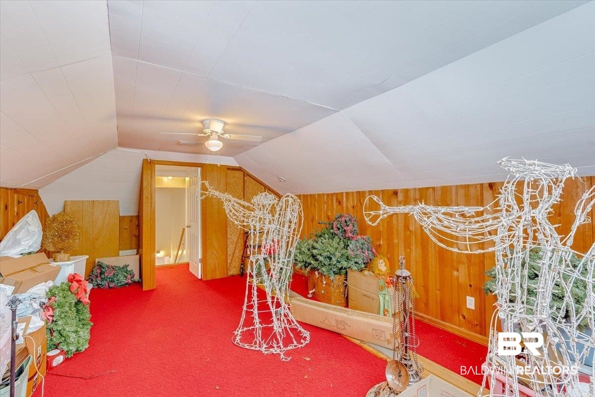 14160 Moffett Road Wilmer, AL 36587 - Photo 40 of 75 Recreation room featuring vaulted ceiling, ceiling fan, wood walls, and carpet flooring