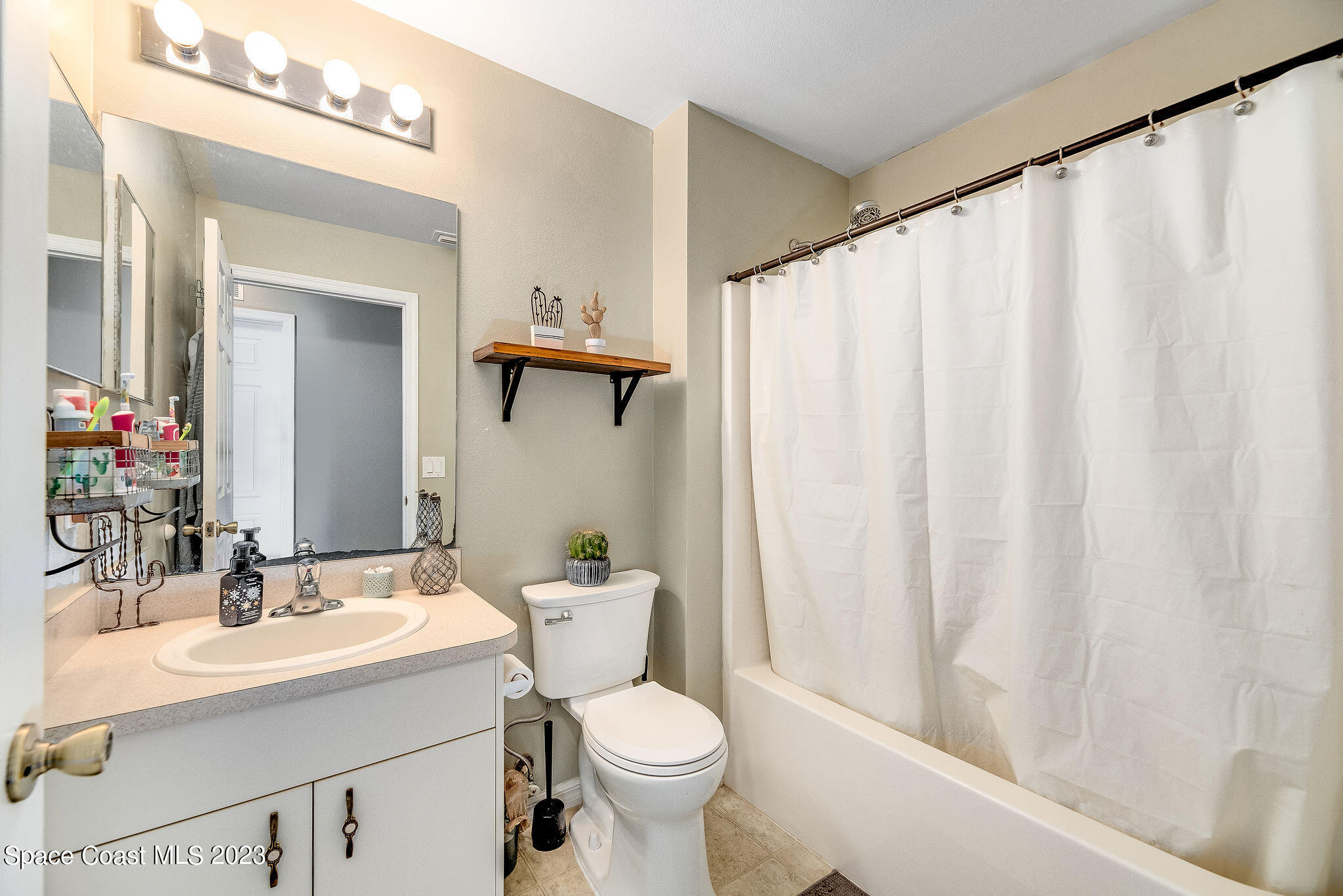6342 Hudson Road Cocoa, FL 32927 - Photo 16 of 30 a bathroom with a sink a toilet and shower curtain