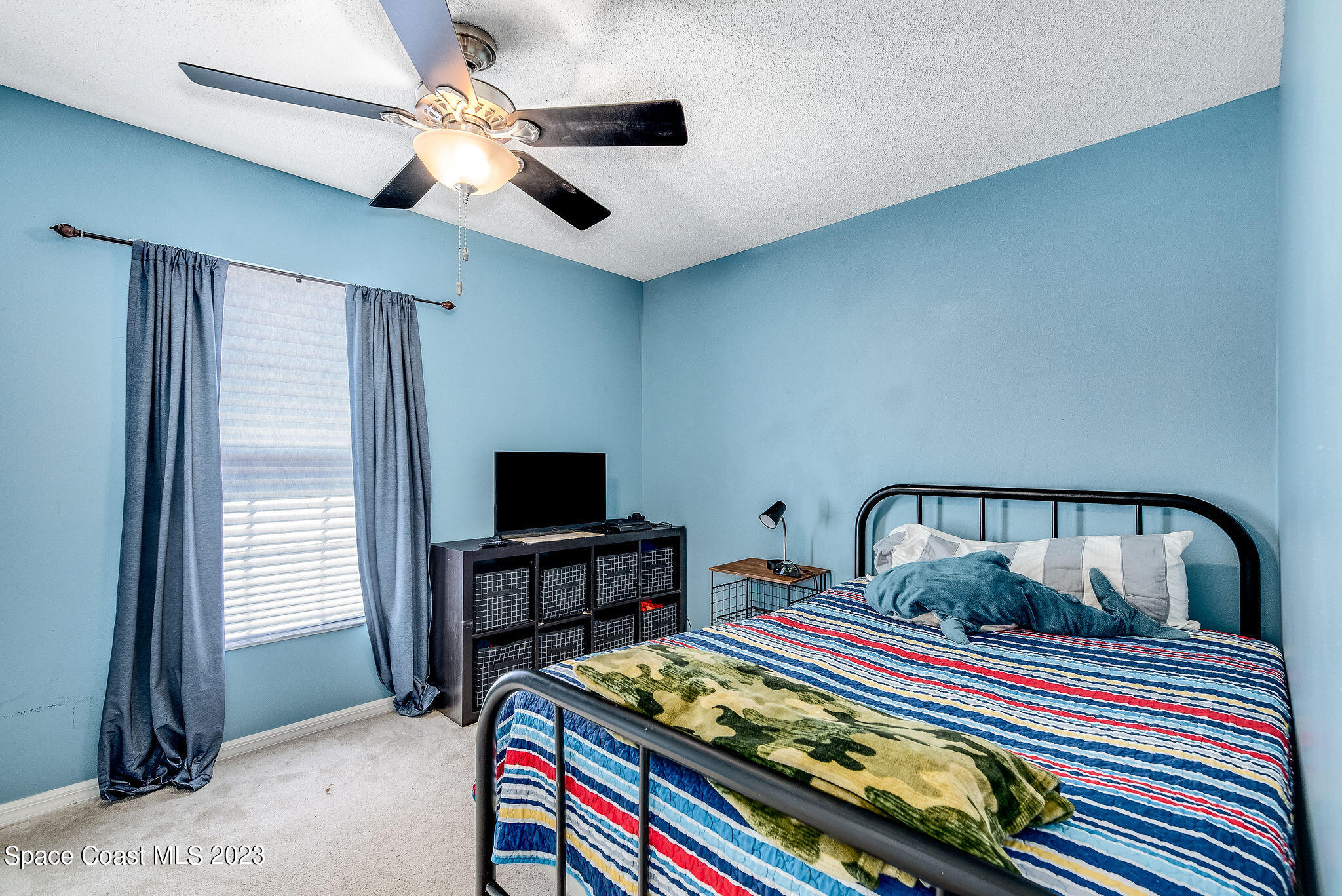 6342 Hudson Road Cocoa, FL 32927 - Photo 17 of 30 a bedroom with a bed and a flat tv screen on the dresser