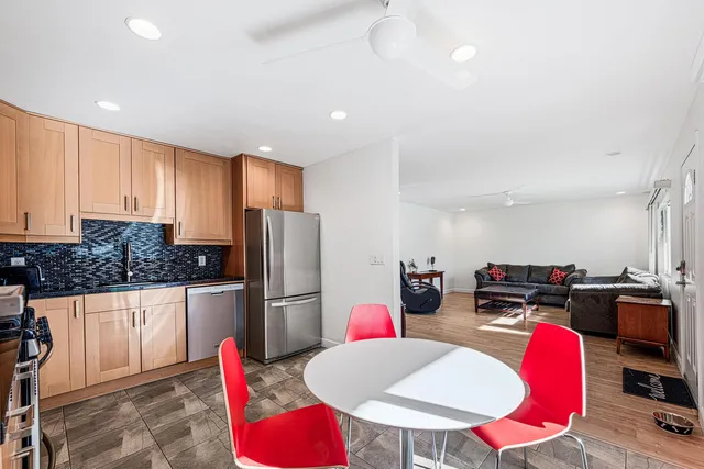a kitchen with stainless steel appliances kitchen island granite countertop a refrigerator a stove a sink dishwasher with a dining table and chairs