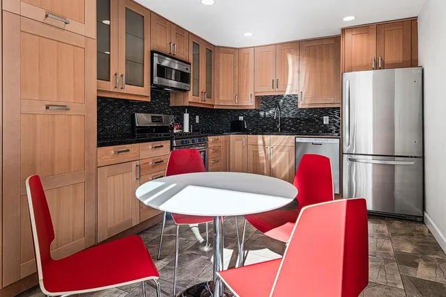 a kitchen with stainless steel appliances granite countertop a refrigerator and microwave