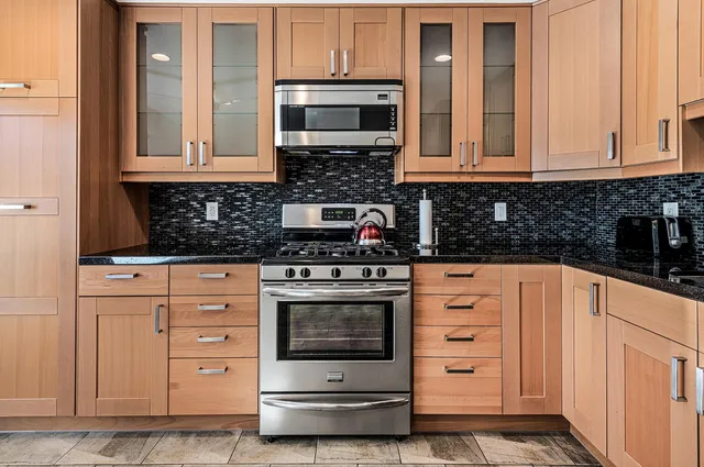 a kitchen with stainless steel appliances granite countertop a stove and a microwave